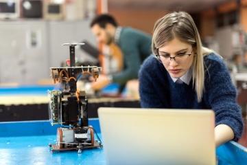 Girls working at a laptop with science equipment beside her